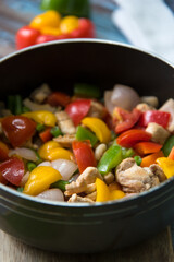 Close up chicken and vegetables saute in a pan