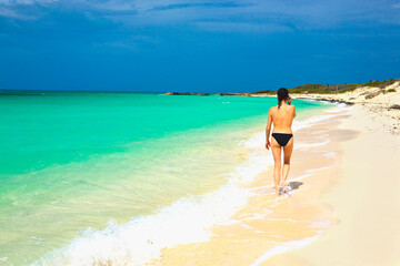 Rear view of a woman walking on the beach, Perla Blanca Beach, Cuba