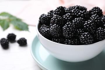 Fresh ripe blackberries in bowl on white table, closeup