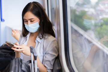 Fototapeta na wymiar Asian woman traveler who sit in the train while using smartphone.
