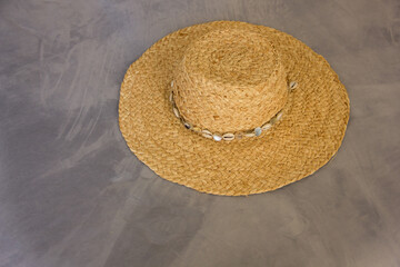 Fototapeta na wymiar closeup straw hat lies on a gray sofa in boho style interior, travel concept, free space