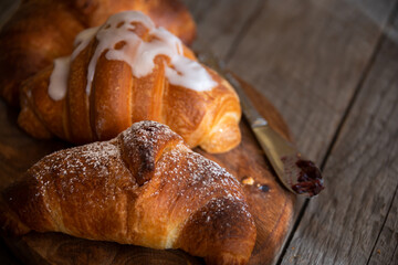 Fresh baked sweet croissants with jam or honey for breakfast