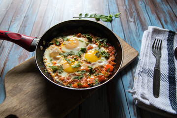 Close up view of fried eggs in a pan on a wooden platter