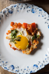 A portion of Shakshouka served on a white plate with use of selective focus