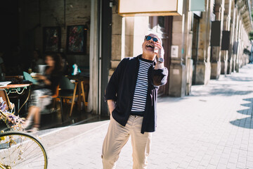 Cheerful man laughing while talking on phone