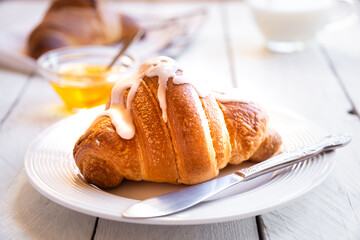 Fresh baked sweet croissants with jam or honey for breakfast