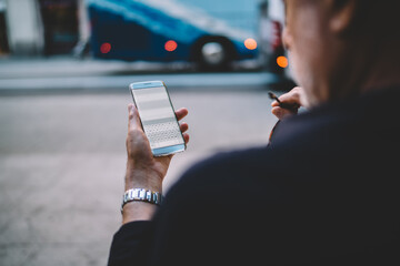 Faceless man browsing Internet on smartphone