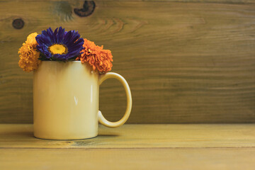 Beautiful flower petals in a cup  on wooden background. 
