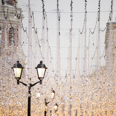 Festive illumination on the city streets. New Year and Christmas decoration on a snowy evening, Red...