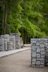 Pavement repair and laying of paving slabs on the walkway, stacked tile cubes on the background. Laying paving slabs in the pedestrian zone of the city, sand filling. Road tiles and curbs
