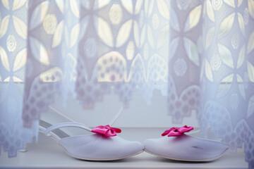 The bride shows white wedding shoes. Wedding detail. Close up.