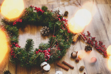 Christmas wreath on wooden rustic background in lights