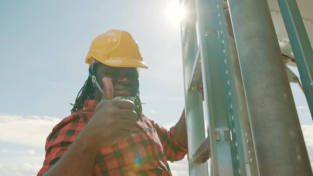 African black man climbing on the leders of the silio system with humbs up. High quality 4k footage