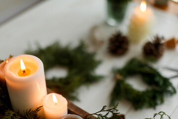 Burning candles on rustic background with christmas wreath, cozy winter advent