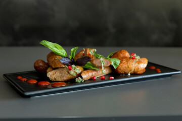 Grilled sausage on a black plate in the original setting. Grilled sausage in the original table setting in the restaurant.