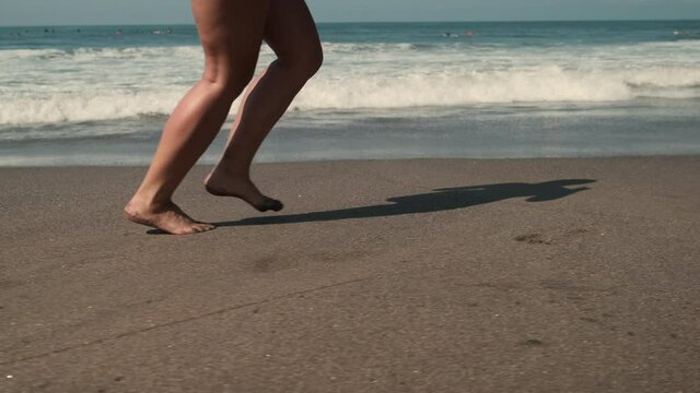 Legs of unknown female jogging along sandy beach