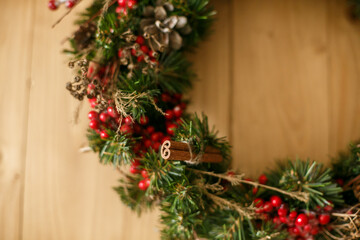 Christmas wreath decor closeup on rustic wooden door in house.