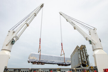 The crane was lifting the locomotive off the ship.