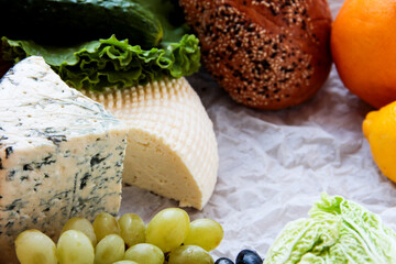 Cheeses, grapes, citrus fruits and bread products. Food package.