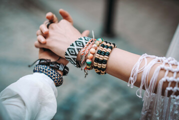 Hands of two young girls wearing hippy clothes with bracelets.  Contemporary bohemian style. Spirit of freedom. Fashion shot.