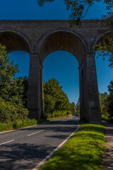 A view of the road passing underneath the Chappel Viaduct near Colchester, UK in the summertime