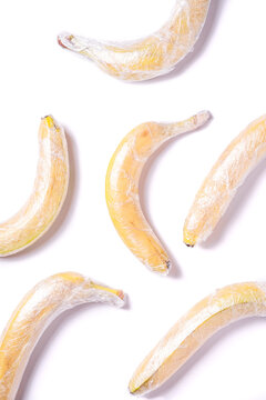 Banana fruits wrapped in stretch wrap plastic isolated background, minimalistic creative layout, ecology and environment concept