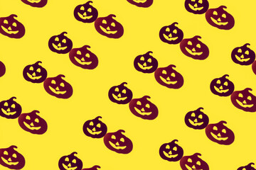 Fototapeta na wymiar Creative beautiful fashion seamless pattern of laughing funny pumpkin silhouette and its shadow on yellow background.The Concept Of Halloween.flat lay