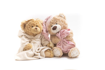 A pair of soft toy bears on a white background. Sleepy bear in a cap with a blanket and a bear in a dress. Concept of friendship, childhood, relationships, sleep, falling asleep, dreams. Horizontal.