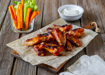 Barbecue chicken wings with carrots, celery and white sauce. Grill. Recipe.