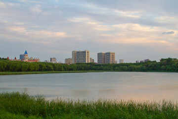 Fototapeta premium Trail in a park with modern residential buildings apartment on the back. Eco-friendly living in a city.