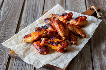 Barbecue chicken wings on a wooden background. Grill. Recipe.