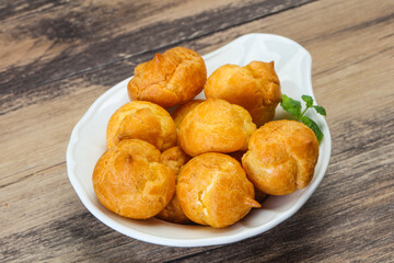 Sweet tasty profiteroles heap in the bowl