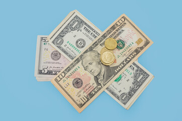 stacks of dollars and coins on a blue background. Financial concept. Bills of $ 1.5.10. View from above