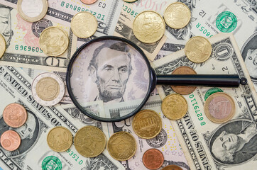 money background and magnifier. Dollars and coins. Financial concept