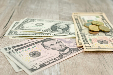 stacks of dollars and coins on a wooden background. Financial concept. $ 1,5.10 bills