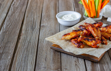 Barbecue chicken wings with carrots, celery and white sauce. Grill. Recipe.