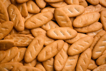 Many delicious crackers as background, top view