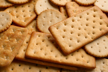 Many delicious crackers as background, closeup view