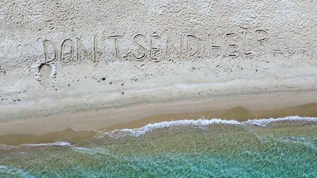 Dont send help message written on sand beach. SOS message aerial view 