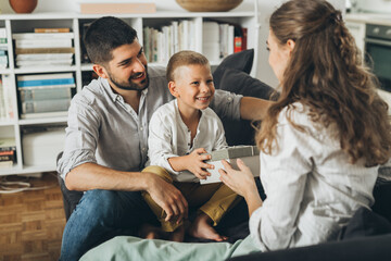 father and son gives gift to the mother at home