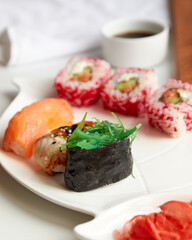 Sushi rolls. Japanese food in the restaurant. Sushi roll with salmon and green seaweed on a wooden board
