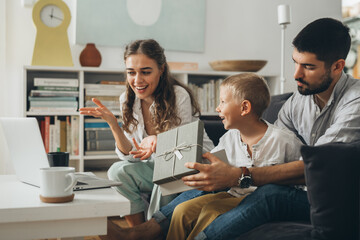 family open gift and having video call on laptop computer at home