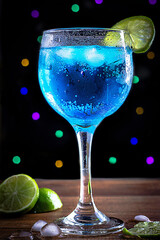 cocktail blue lagoon (blue curacao) with lime on black background party vibe