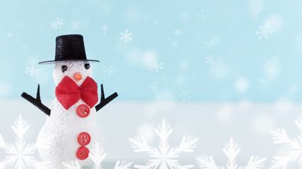 Funny snowman standing in snow over winter background.