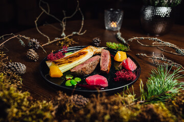 Fresh duck meat steak in Michelin star restaurant. Food table with forest decorations. Michelin food