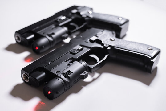 Pair of black toy guns with laser aim on a white background.