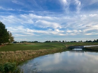 Fototapeta na wymiar golf course landscape with river and blue sky