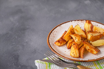Delicious baked potato wedges with spices. Copy space.