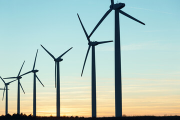 Wind Turbines at Dusk. Landscape sunset with windmills. Renewal source of electricity. Wind turbines field new technology for clean energy on mountain, sunset view with colorful twilight on sky.