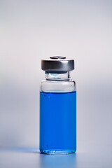 Medical blue vial with solution for injection on white background